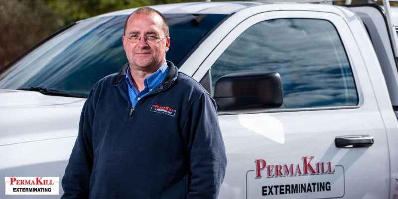 Permakill employee in front of the work truck